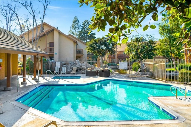 pool featuring a patio area and fence