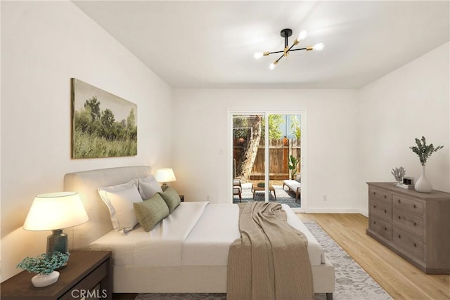 bedroom featuring a notable chandelier, access to outside, baseboards, and light wood-style floors