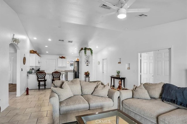 living room featuring visible vents, lofted ceiling, recessed lighting, arched walkways, and a ceiling fan