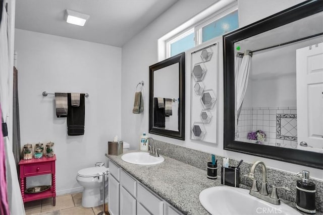 bathroom featuring double vanity, tile patterned floors, toilet, and a sink