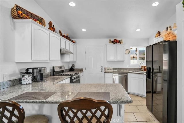 kitchen featuring under cabinet range hood, a sink, appliances with stainless steel finishes, a peninsula, and white cabinets