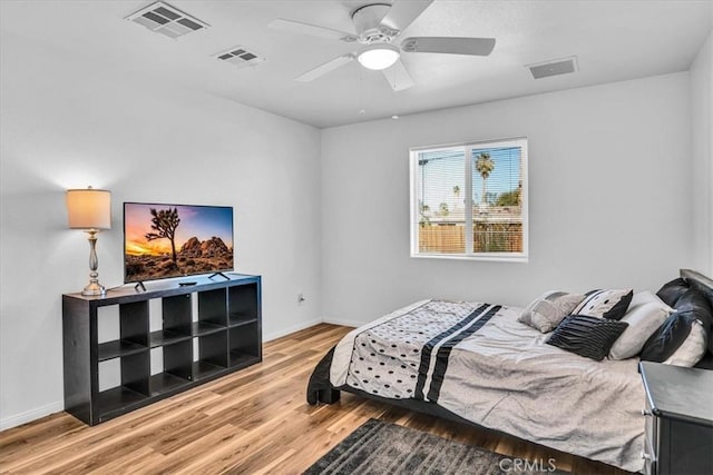 bedroom featuring visible vents, baseboards, and wood finished floors