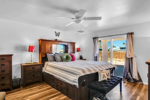 bedroom with light wood finished floors, ceiling fan, and access to outside