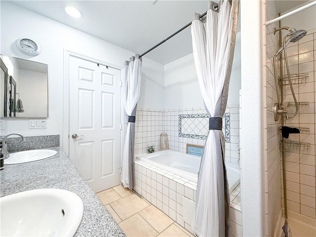 bathroom with tile patterned floors, double vanity, tiled shower / bath combo, and a sink