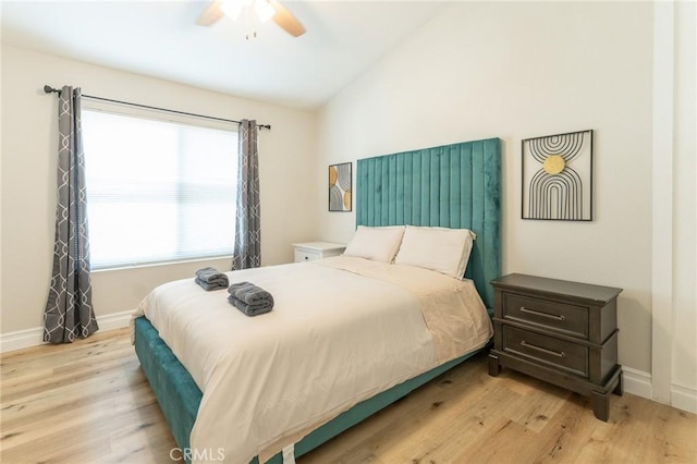 bedroom with a ceiling fan, lofted ceiling, light wood-style flooring, and baseboards