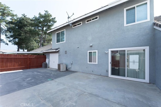 back of house featuring a patio, fence, cooling unit, and stucco siding