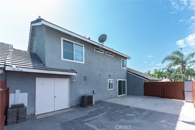 back of property featuring central AC, a patio, fence, and stucco siding