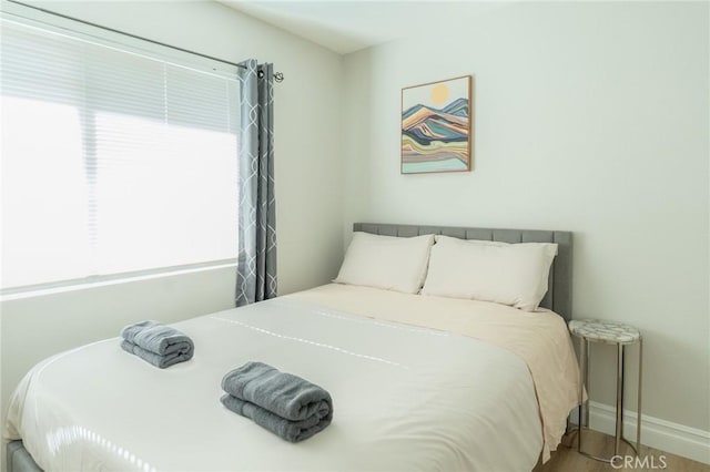 bedroom with baseboards and wood finished floors