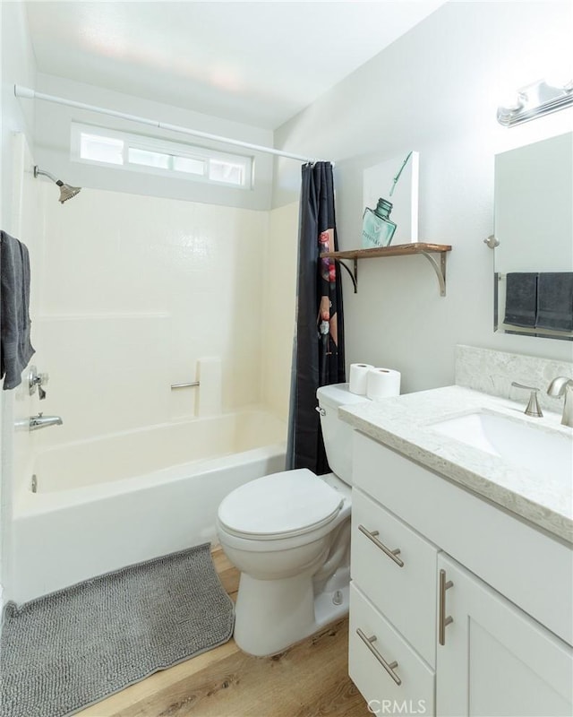 full bath featuring vanity, wood finished floors, toilet, and shower / bathtub combination with curtain