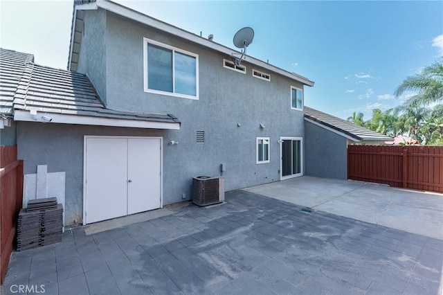 back of property with fence, a patio, and stucco siding