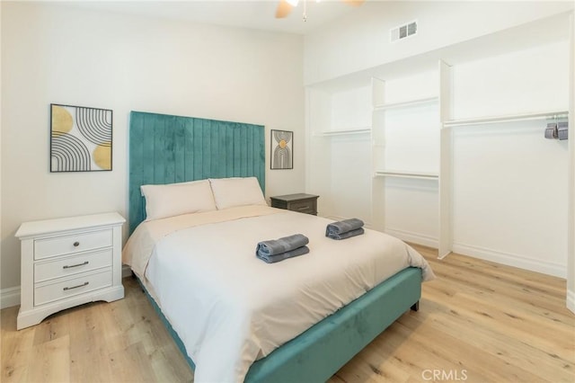 bedroom with light wood-type flooring, baseboards, and visible vents