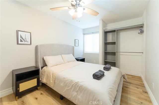 bedroom featuring ceiling fan, light wood-style flooring, and baseboards