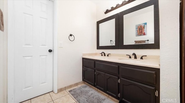 full bathroom with double vanity, a sink, and tile patterned floors