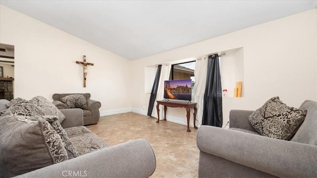 living room featuring vaulted ceiling and baseboards