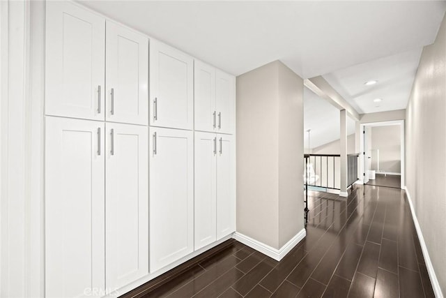 hallway featuring dark wood-type flooring, recessed lighting, an upstairs landing, and baseboards