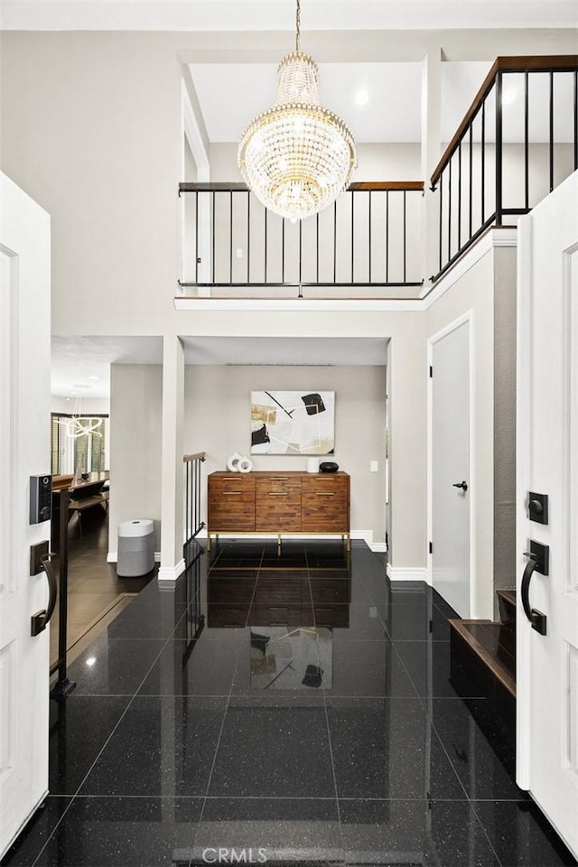 entrance foyer featuring a high ceiling, granite finish floor, and baseboards