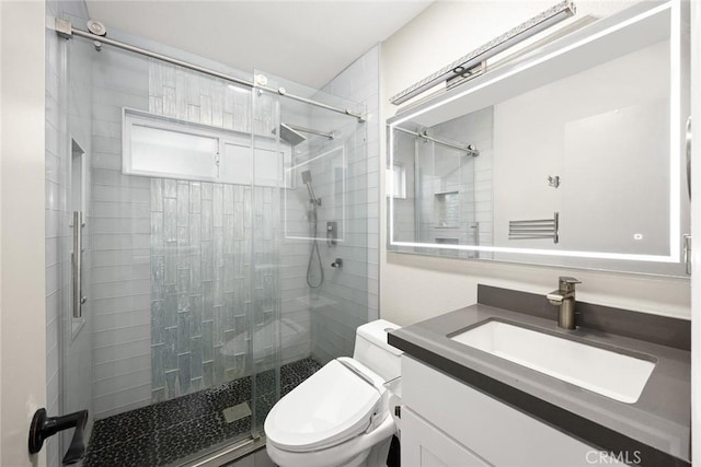 full bathroom featuring a stall shower, vanity, and toilet