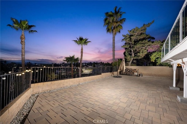 patio terrace at dusk with a fenced backyard