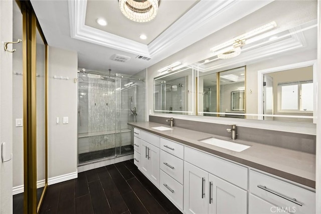 full bath featuring wood finished floors, a raised ceiling, ornamental molding, and a sink