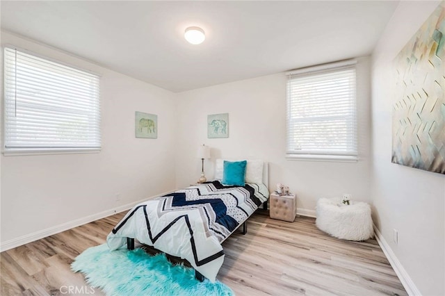 bedroom with light wood finished floors and baseboards