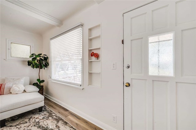 living area featuring wood finished floors, built in features, and baseboards