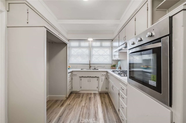 kitchen with stainless steel appliances, crown molding, light countertops, light wood-type flooring, and under cabinet range hood