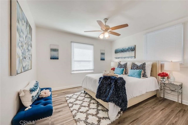 bedroom featuring ceiling fan, baseboards, and wood finished floors