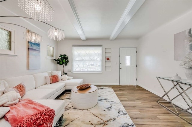 living area with beamed ceiling, baseboards, and wood finished floors