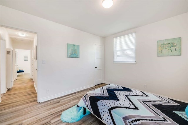 bedroom with baseboards and light wood finished floors