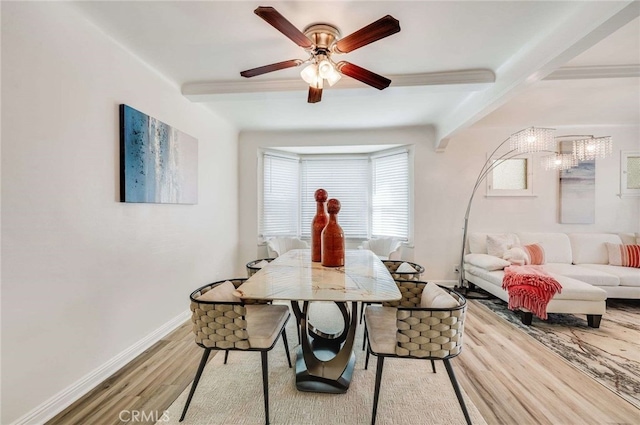 dining area featuring a ceiling fan, light wood-style flooring, baseboards, and beamed ceiling