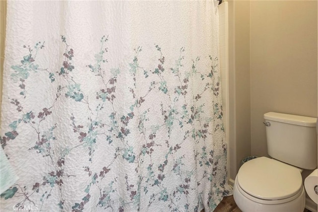 bathroom with a shower stall and toilet