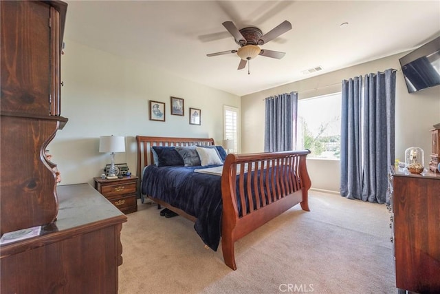 bedroom featuring ceiling fan, visible vents, and light colored carpet