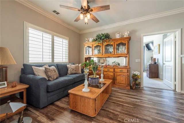 living room with dark wood-style floors, visible vents, crown molding, and ceiling fan