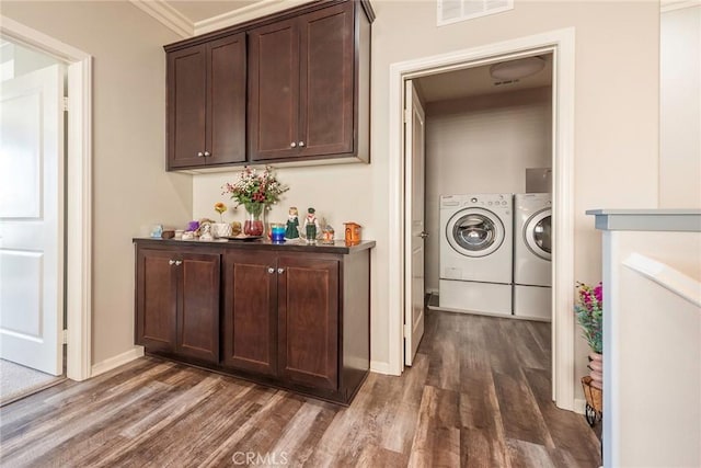 laundry area with dark wood-style floors, visible vents, washer and dryer, laundry area, and baseboards