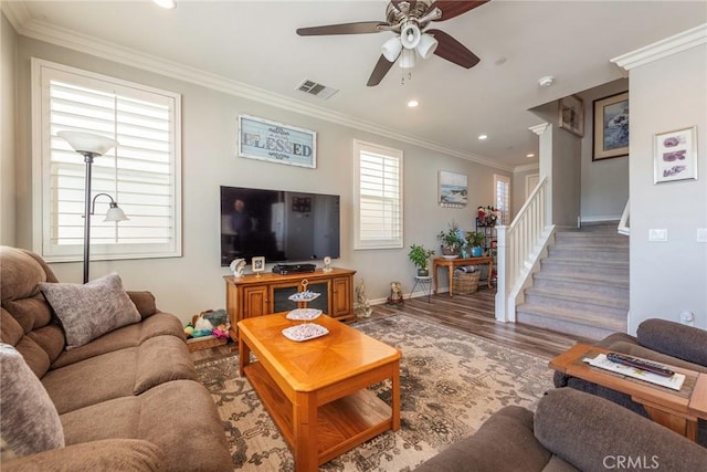 living area featuring dark wood finished floors, crown molding, visible vents, stairway, and baseboards