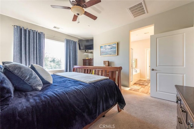 bedroom with light carpet, a ceiling fan, visible vents, and connected bathroom