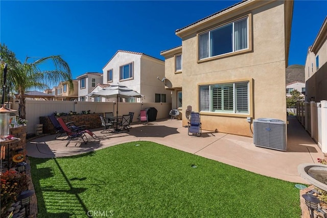 back of property featuring cooling unit, a fenced backyard, a yard, and stucco siding