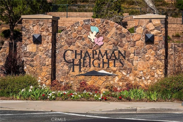 community / neighborhood sign featuring fence