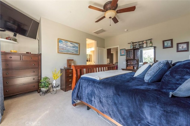 bedroom with light carpet, ensuite bath, visible vents, and a ceiling fan