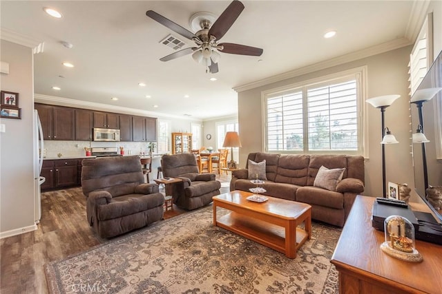 living area featuring dark wood-style floors, ornamental molding, visible vents, and recessed lighting