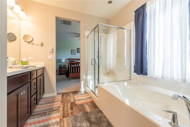 bathroom featuring vanity, visible vents, a bath, a stall shower, and ensuite bath