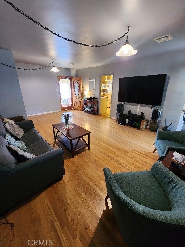 living area with light wood-type flooring and visible vents