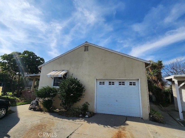 view of side of home featuring driveway and stucco siding