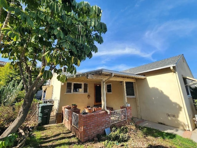 back of house featuring fence and stucco siding