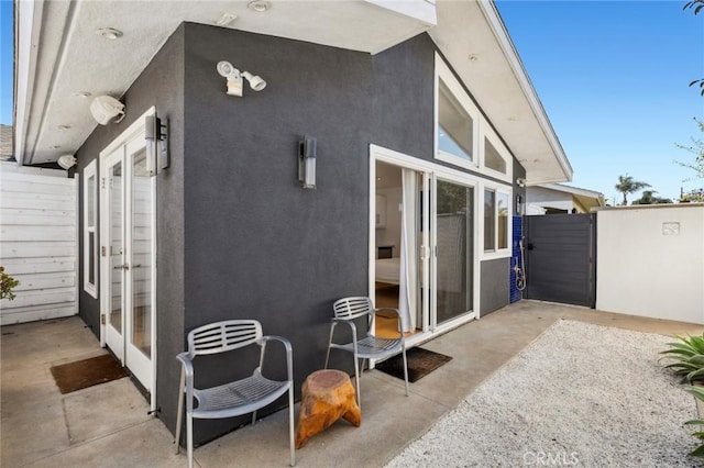 exterior space featuring a patio, fence, and stucco siding