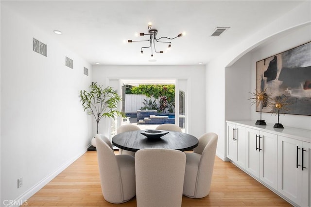 dining room featuring a notable chandelier, visible vents, and light wood-style flooring