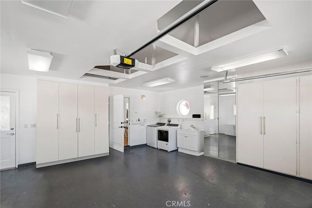 garage with a sink, a garage door opener, and washer and clothes dryer