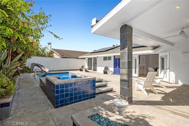 view of patio with a ceiling fan, an in ground hot tub, and a fenced backyard