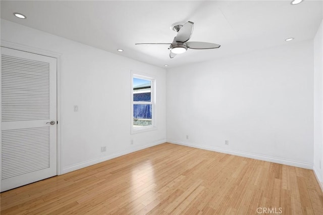 spare room with recessed lighting, light wood-style flooring, a ceiling fan, and baseboards