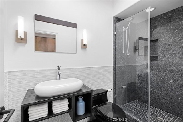 full bath with wainscoting, a shower stall, tile walls, and vanity